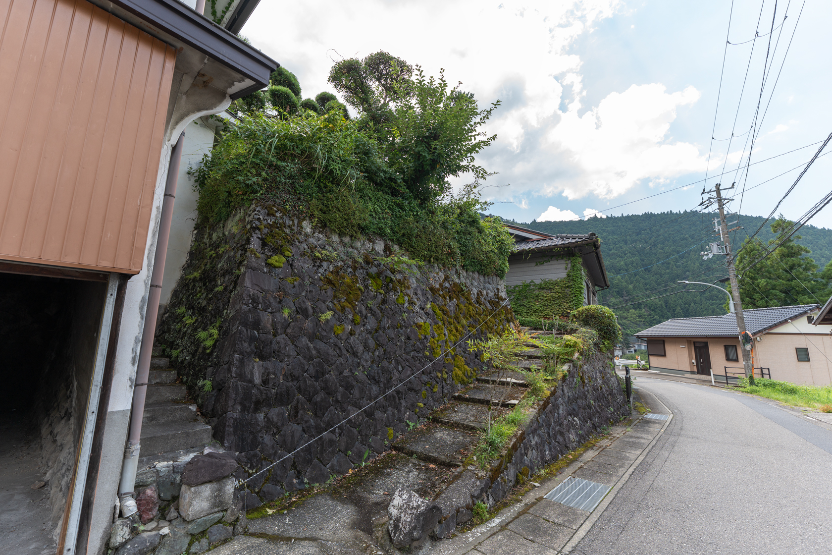 奈良県十津川村大字上野地：外観。擁壁と道路のカーブごしに見た建物。