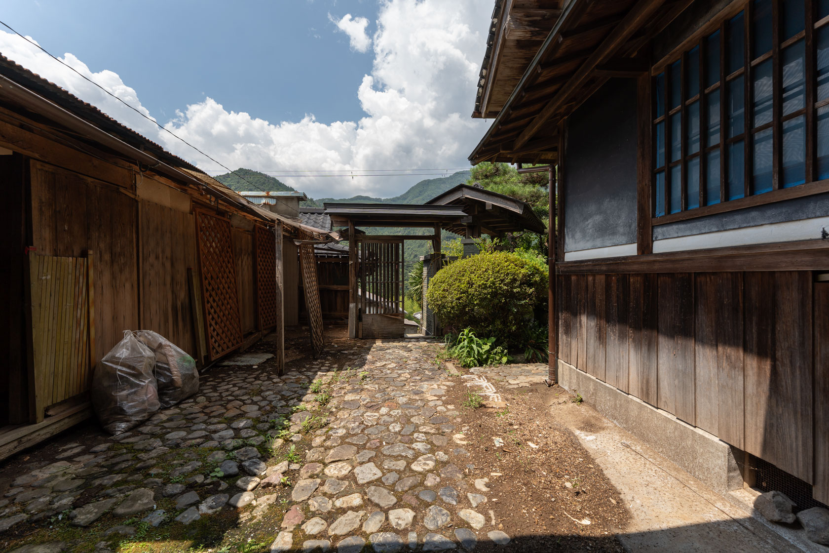 奈良県十津川村大字上野地：敷地内の石畳の小径。緑に囲まれたアプローチ。